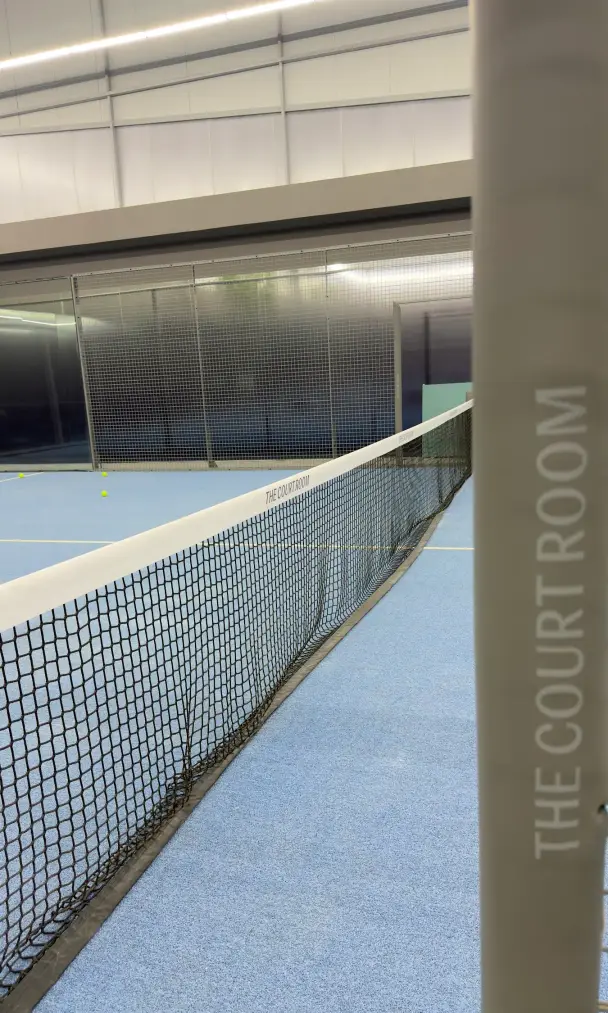 Net post marked The Court Room, looking down the court